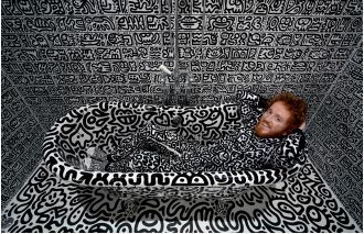 An artist who decorated his million-pound mansion with doodles is now working on a mural in the local town.