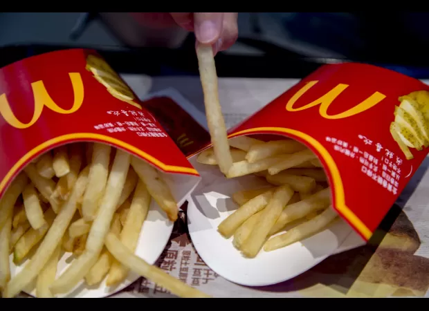 The person considers which size of McDonald's French fries would be the best to purchase.