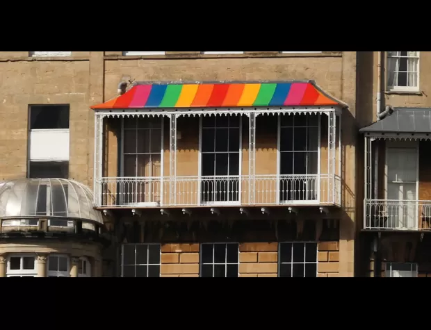 Homeowner inundated with criticism for painting balcony in rainbow colors.