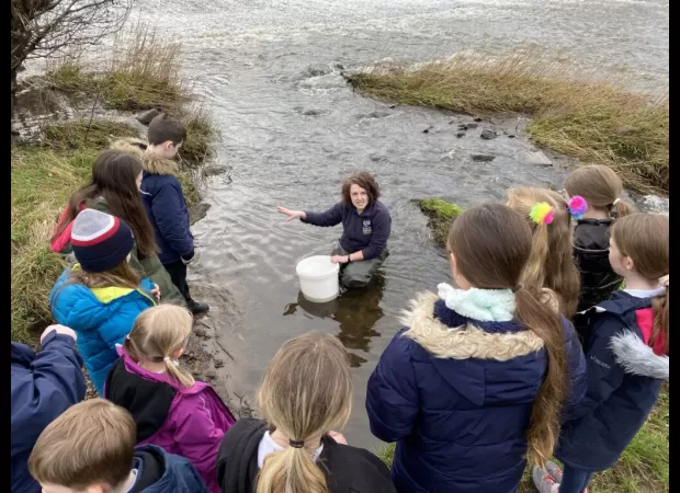 Five students experience a hands-on learning opportunity as they raise fish in their classroom.