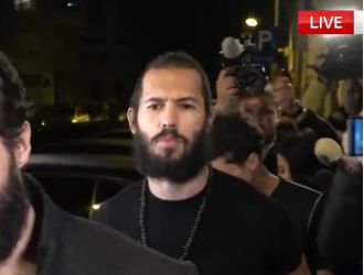 Andrew Tate posts video of himself walking around shirtless, smoking a cigar.