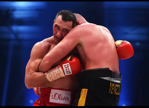 Boxers hold each other to rest and regain energy, as well as show respect for each other.