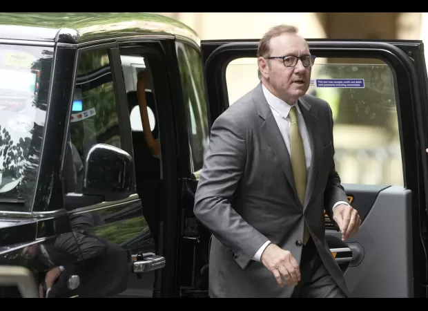 Kevin Spacey arrives at court with a smile on his face as prosecutors prepare to begin trial for sexual assault in London.
