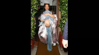 Rihanna looks cool as a mom while showing off baby bump, carrying her son and wearing a flashy silk jacket.