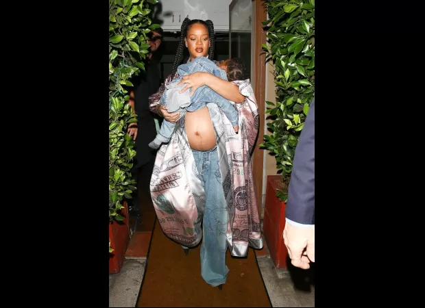Rihanna looks cool as a mom while showing off baby bump, carrying her son and wearing a flashy silk jacket.