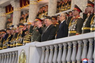 Kim & Putin's defence chief laugh as nukes roll by at military parade.