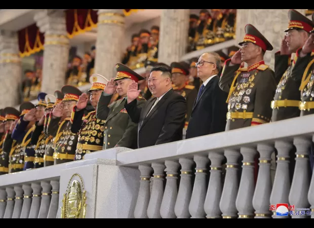 Kim & Putin's defence chief laugh as nukes roll by at military parade.