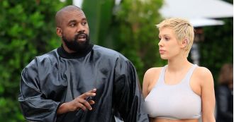 Kanye West admiring his wife Bianca's sheer outfit as she steps out.