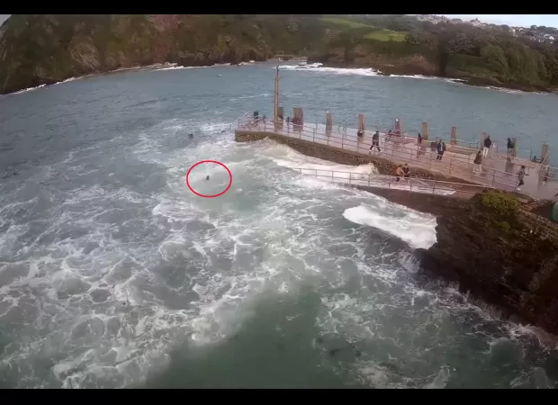 Woman is pulled out to sea by a powerful wave.