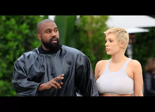 Kanye West admiring his wife Bianca's sheer outfit as she steps out.