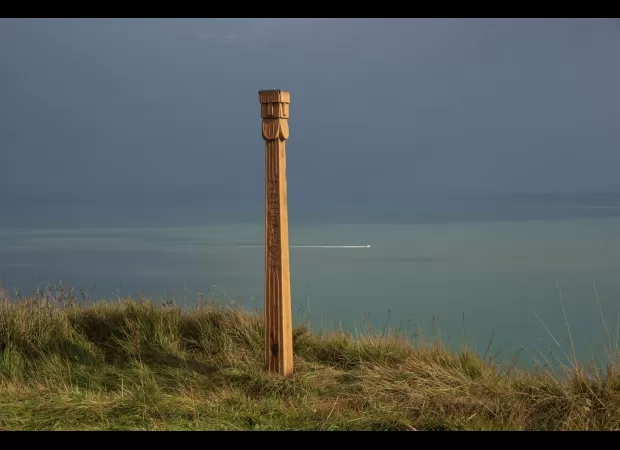 A mysterious totem pole with the name of a thunder god has been found along a coastal path.