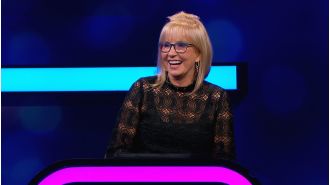 TV host returns to game show after 9 years away, following partner's death.