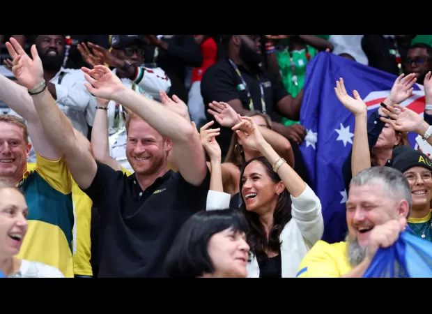 Harry and Meghan show affection as they mingle with spectators at Invictus Games.