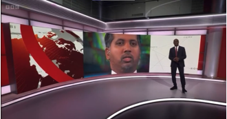 Clive Myrie laughs after a BBC camera gets too close and personal during a live broadcast.