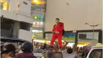 Man in Jaipur arrested after driving around, throwing ₹10 & ₹20 notes from atop his car while wearing 'Money Heist' costume.