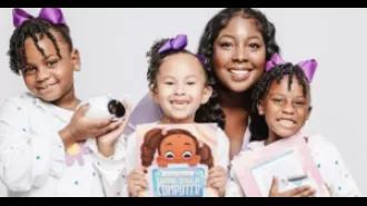 Female computer scientist inspiring black kids to learn coding through interactive toy robot and book series.