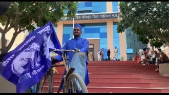 Tea seller rides a bicycle to bid for political success in a unique blue style.