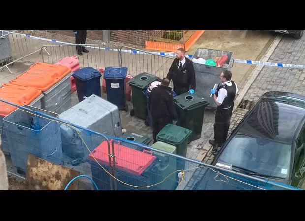 Body of woman discovered in large plastic container with wheels.