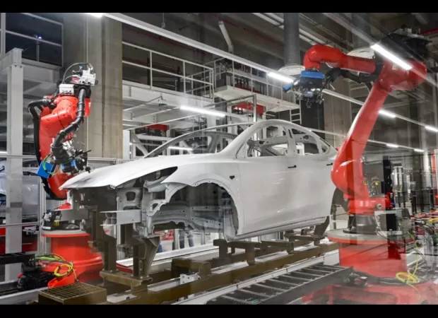 Engineer attacked by robot while working in Tesla car factory.