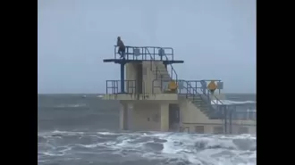 Despite being warned, a diver recklessly enters rough waters caused by Storm Isha.
