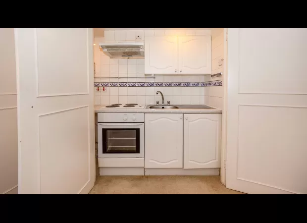 Cozy studio apartment with a compact kitchen available for rent at £800 per month.