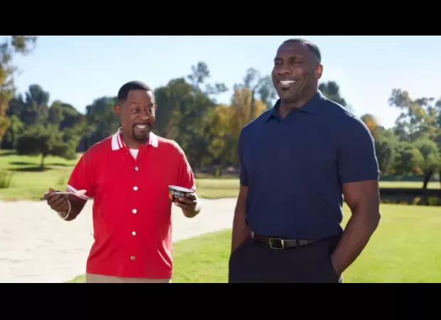 Martin Lawrence shows off his muscles to impress Shannon Sharpe in an Oikos Super Bowl ad.