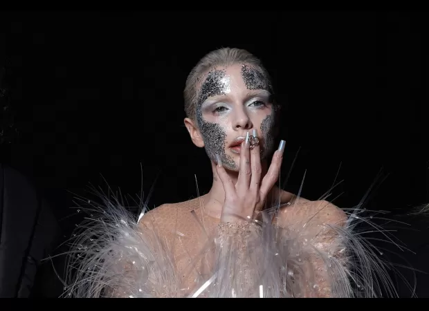 Actress Julia Fox shows off her behind in a revealing nude bodysuit adorned with plastic hair on her chest.