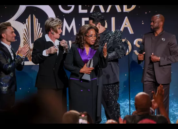 A chaotic moment as woman falls onstage while presenting Oprah Winfrey an award.