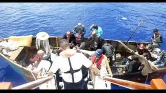 A cruise ship saves migrants from a small boat seeking assistance.