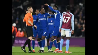 A Chelsea player loudly confronts the referee and is forcibly removed during a tense moment.