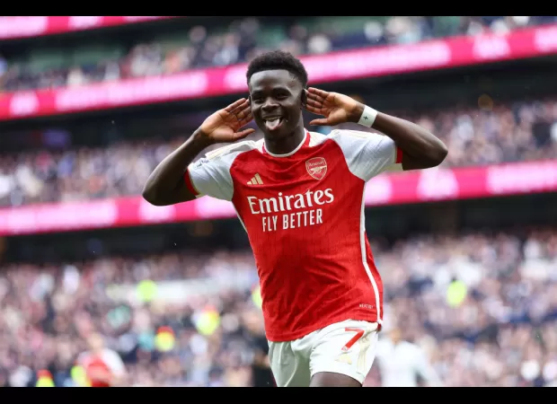 Arsenal stays in the race for the title by narrowly defeating Tottenham in a tense north London derby.