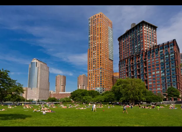 A couple was seen engaging in sexual activity under a blanket in a crowded park.