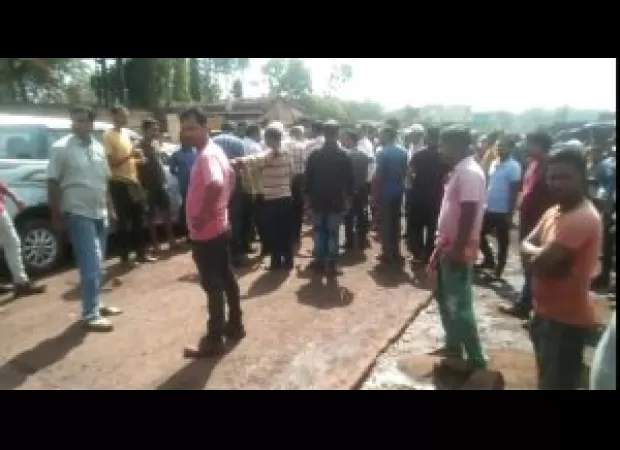 Protesters stop official from entering plant grounds, demanding better working conditions.