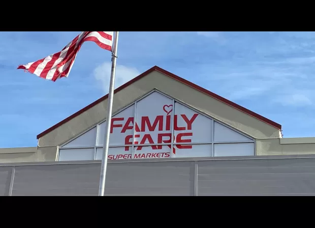 A woman living on the streets creates a makeshift office in a store sign with computer and coffee maker.