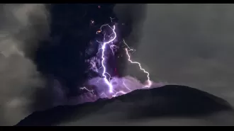 Purple lightning flashes around erupting volcano in stunning images.