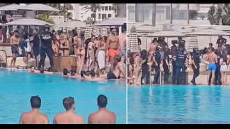 Police with weapons enter Marbella beach club and tell individuals to leave the pool.