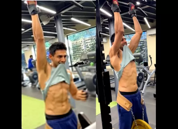 Kartik Aaryan shows off toned abs while doing weight-lifted pull-ups.