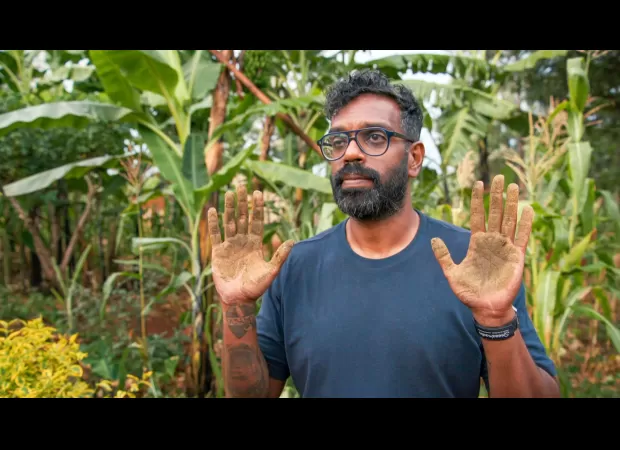 Romesh Ranganathan remains calm after handling cow feces with his bare hands.
