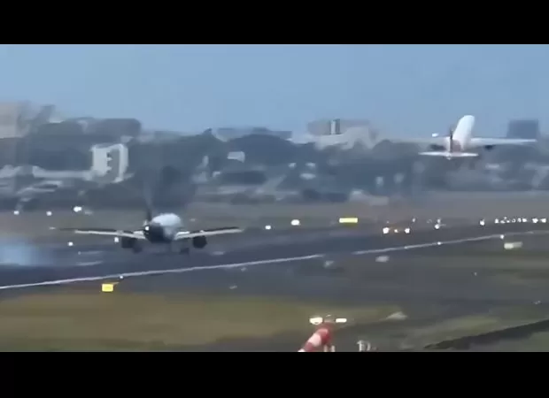 Two planes narrowly avoid collision as one lands only moments after another takes off.