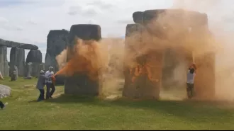 Activists detained for coloring Stonehenge orange in climate protest.