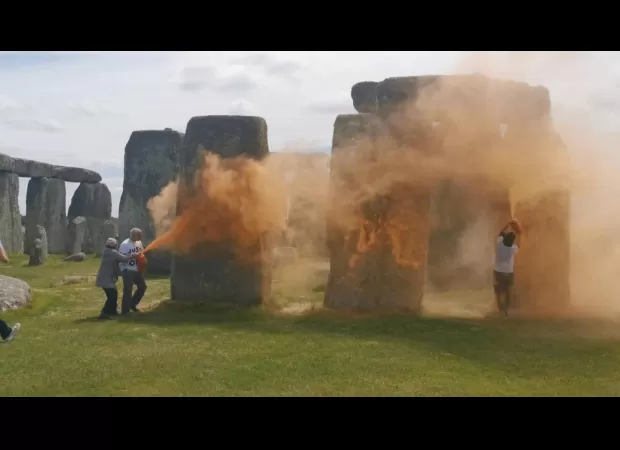 Activists detained for coloring Stonehenge orange in climate protest.