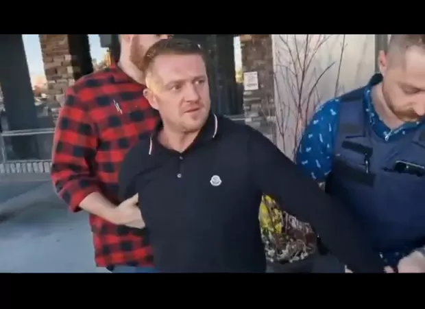 Tommy Robinson arrested for suspected immigration violation, taken away in handcuffs.