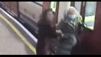Elderly woman gets coat stuck in train door and is pulled along platform.