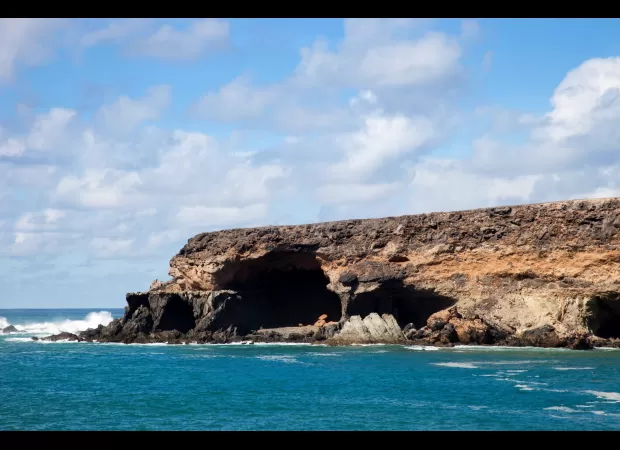 A woman from Britain has passed away after being carried away by a wave at well-known caves in the Canary Islands.