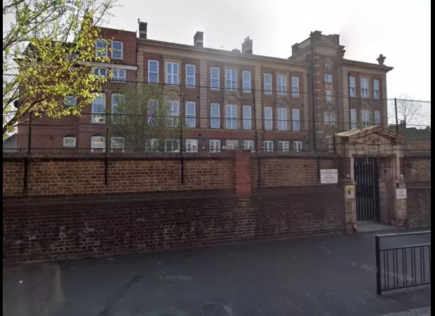 A head teacher received £100,000 after being fired for tapping a toddler's hand, deemed as an 