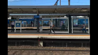 A woman was pushed onto Melbourne train tracks by a stranger and is now in the hospital.