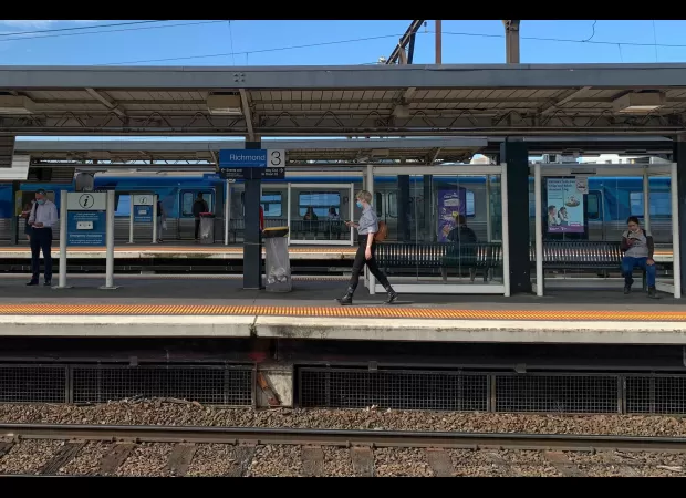 A woman was pushed onto Melbourne train tracks by a stranger and is now in the hospital.
