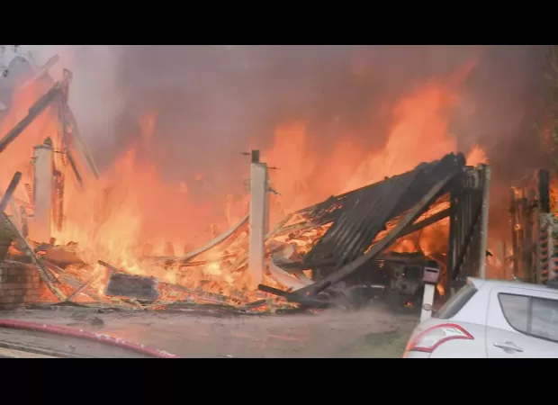 A huge fire ravages three houses in Brisbane, causing massive destruction.