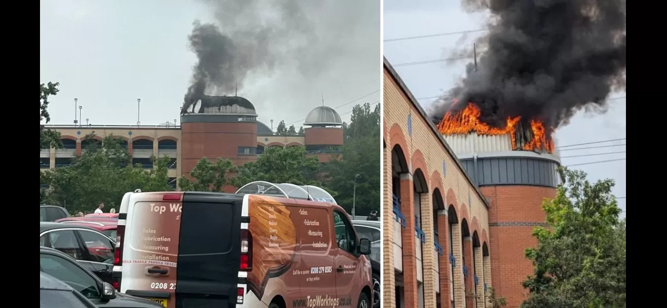 A shopping center is on fire, with large clouds of smoke billowing into the air.