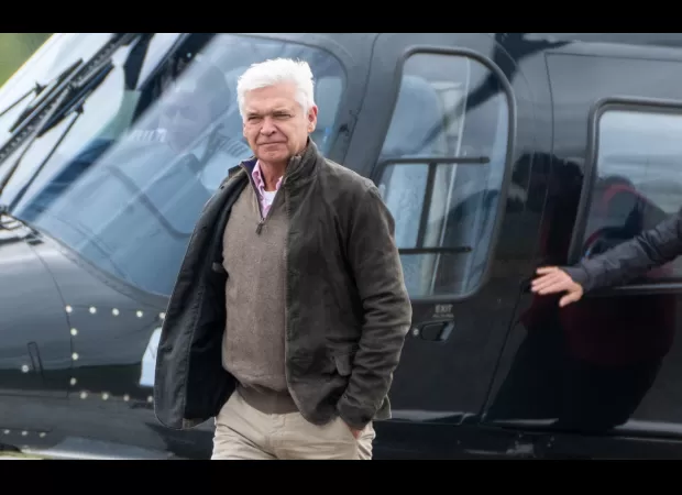 Phillip Schofield arrives at Silverstone for Grand Prix by helicopter in rare public outing.